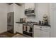 Close up of the kitchen with stainless steel appliances, white cabinets and black countertop at 1379 S Claiborne Ave, Gilbert, AZ 85296