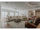 Bright living room with a very large sofa, neutral decor, natural light, and an area rug over hardwood floors at 1379 S Claiborne Ave, Gilbert, AZ 85296