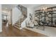 Stylish living room with light wood floors, modern shelving, and a staircase with black metal railings at 1379 S Claiborne Ave, Gilbert, AZ 85296