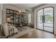 Stylish living room with hardwood floors, built-in shelving, and a large window-paned front door at 1379 S Claiborne Ave, Gilbert, AZ 85296