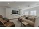 Bright living room with large tv, light colored sofa, and multiple arm chairs and seating at 1379 S Claiborne Ave, Gilbert, AZ 85296