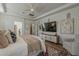 This expansive bedroom boasts neutral decor, a ceiling fan, and a large TV above a storage cabinet at 1379 S Claiborne Ave, Gilbert, AZ 85296