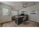 Office with hardwood floors, neutral paint, ceiling fan, and a desk with two computer monitors and gray upholstered chairs at 1379 S Claiborne Ave, Gilbert, AZ 85296