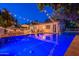 Outdoor view of a sparkling pool and spa at dusk with string lights overhead, next to an outdoor kitchen at 1379 S Claiborne Ave, Gilbert, AZ 85296