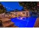 Outdoor view of a beautiful pool and spa at dusk with string lights overhead, next to an outdoor kitchen at 1379 S Claiborne Ave, Gilbert, AZ 85296