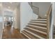 Bright entryway featuring light wood floors and an elegant staircase with wooden steps and dark metal railings at 1379 S Claiborne Ave, Gilbert, AZ 85296