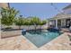 Elegant pool with a spa, surrounded by a travertine patio, and lush landscaping creates a private retreat at 1379 S Claiborne Ave, Gilbert, AZ 85296
