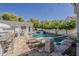 Stunning backyard oasis featuring a sparkling pool, spa, travertine patio, and string lights for a relaxing ambiance at 1379 S Claiborne Ave, Gilbert, AZ 85296