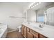 Bathroom vanity with double sinks, large mirror, and shower-tub combo at 14625 W Redfield Rd, Surprise, AZ 85379