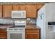 Functional kitchen features white appliances, oak cabinets and stone countertops at 14625 W Redfield Rd, Surprise, AZ 85379