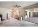 Bedroom featuring multiple dressers and ceiling fan, leading to a bright sunroom at 15438 N Lakeforest Dr, Sun City, AZ 85351