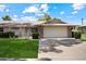 Charming single-story home with a well-manicured lawn and a two-car garage at 15438 N Lakeforest Dr, Sun City, AZ 85351