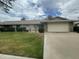 Well-maintained single Gathering house with a green lawn, shrubs, brick accents, and two car garage at 15438 N Lakeforest Dr, Sun City, AZ 85351
