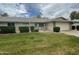 Well-maintained single Gathering house with a green lawn, shrubs, brick accents, and two car garage at 15438 N Lakeforest Dr, Sun City, AZ 85351
