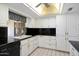 Kitchen with black countertops, white cabinetry, and views out to the yard at 15438 N Lakeforest Dr, Sun City, AZ 85351