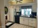Bright kitchen featuring white cabinets, black countertops, and black and white checkered window coverings at 15438 N Lakeforest Dr, Sun City, AZ 85351