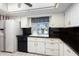 Kitchen with black countertops, white cabinetry, and a view to the outdoors at 15438 N Lakeforest Dr, Sun City, AZ 85351