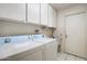 Functional laundry room with white cabinets and a washer and dryer set at 15438 N Lakeforest Dr, Sun City, AZ 85351