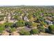 Expansive aerial view of a neighborhood with lush trees and blue mountain views in the distance at 2545 E Harrison Ct, Gilbert, AZ 85295