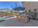 Outdoor kitchen featuring a built-in grill, refrigerator, and bar seating adjacent to a beautiful pool at 2545 E Harrison Ct, Gilbert, AZ 85295
