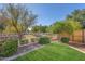 Well-manicured backyard with green grass and a wrought iron fence offering a serene outdoor space at 2545 E Harrison Ct, Gilbert, AZ 85295