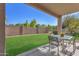 Inviting backyard with a covered patio, lush green lawn, and privacy fence, perfect for outdoor enjoyment at 2545 E Harrison Ct, Gilbert, AZ 85295