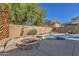 Backyard oasis showcasing a built-in fire pit and outdoor kitchen area, with a sparkling pool for luxurious living at 2545 E Harrison Ct, Gilbert, AZ 85295
