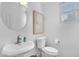 Bright bathroom featuring a pedestal sink, a round mirror, and a window with bright light at 2545 E Harrison Ct, Gilbert, AZ 85295