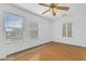 Bright bedroom with wood floors, two windows with blinds, and a ceiling fan at 2545 E Harrison Ct, Gilbert, AZ 85295