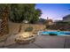 Backyard with a cozy stone fire pit and a sparkling pool, perfect for relaxing evenings at 2545 E Harrison Ct, Gilbert, AZ 85295
