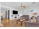 Comfortable living room featuring hardwood floors, ceiling fan and a stylish entertainment center at 2545 E Harrison Ct, Gilbert, AZ 85295