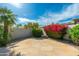 Charming stone patio with colorful landscaping, palm tree, and well-maintained backyard at 6428 E Nisbet Rd, Scottsdale, AZ 85254