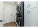 Well-lit laundry room featuring a stacked washer and dryer and white cabinets for storage at 6428 E Nisbet Rd, Scottsdale, AZ 85254