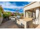 Outdoor kitchen and grill area with stone countertops, bar seating, and view of the pool and patio at 6428 E Nisbet Rd, Scottsdale, AZ 85254
