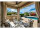 Beautiful outdoor patio with comfortable seating overlooks a sparkling swimming pool and manicured backyard at 6428 E Nisbet Rd, Scottsdale, AZ 85254