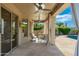 Covered patio with stone floors, comfortable seating, a ceiling fan and a pool view at 6428 E Nisbet Rd, Scottsdale, AZ 85254