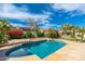 Backyard pool surrounded by lush landscaping and a stone patio under a bright, sunny sky at 6428 E Nisbet Rd, Scottsdale, AZ 85254