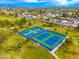 Aerial view of community tennis courts surrounded by lush green lawns and mature trees in a suburban neighborhood at 6428 E Nisbet Rd, Scottsdale, AZ 85254