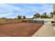 Gravel backyard with partially fenced pool and patio at 702 W Sequoia Dr, Phoenix, AZ 85027