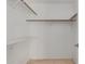 Well-lit walk-in closet with wooden rods and shelving, providing ample storage space at 702 W Sequoia Dr, Phoenix, AZ 85027