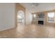 Bright living room with a painted brick fireplace and arched doorway leading to the kitchen at 702 W Sequoia Dr, Phoenix, AZ 85027