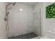 Beautiful walk-in shower with marble tile, rainfall showerhead and a frameless glass enclosure at 702 W Sequoia Dr, Phoenix, AZ 85027