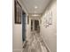 Long hallway showcases modern tile flooring and stylish wall art, leading to various rooms at 7616 W Jones Ave, Phoenix, AZ 85043