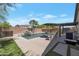 Outdoor living space with inviting pool, rock waterfall, patio dining area, and well-manicured yard at 8524 S 49Th Ln, Laveen, AZ 85339