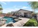 Spacious backyard featuring a pool, rock waterfall, patio area, and lush landscaping at 8524 S 49Th Ln, Laveen, AZ 85339