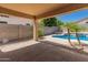 Covered patio with a view of the pool and lush landscaping, offering shade and relaxation at 9852 W Salter Dr, Peoria, AZ 85382