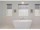 Relaxing bathroom features a soaking tub, unique lighting and window privacy blocks at 10934 E La Verna Way, Scottsdale, AZ 85262