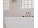 Close up of soaking tub with brushed gold faucet and window privacy blocks at 10934 E La Verna Way, Scottsdale, AZ 85262