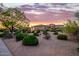 Desert landscaping surrounds a stunning home beneath a vibrant sunset sky at 10934 E La Verna Way, Scottsdale, AZ 85262