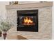 Close-up of a cozy fireplace with decorative stone surround and a warm, inviting flame at 10934 E La Verna Way, Scottsdale, AZ 85262